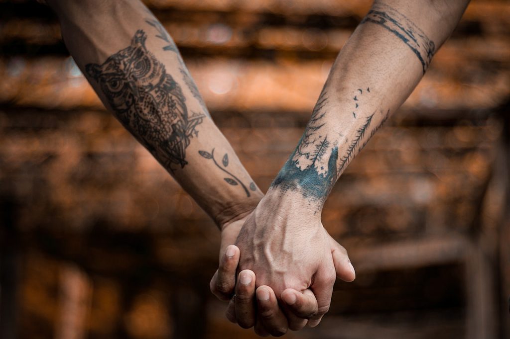 Persone tatuate si tengono per mano