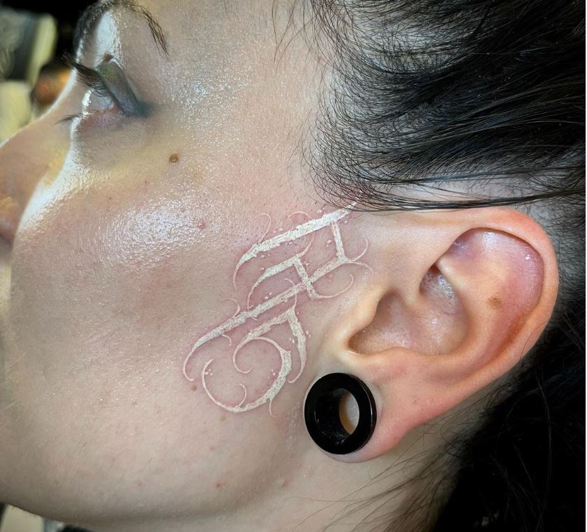 Tatuaggio bianco sugli zigomi