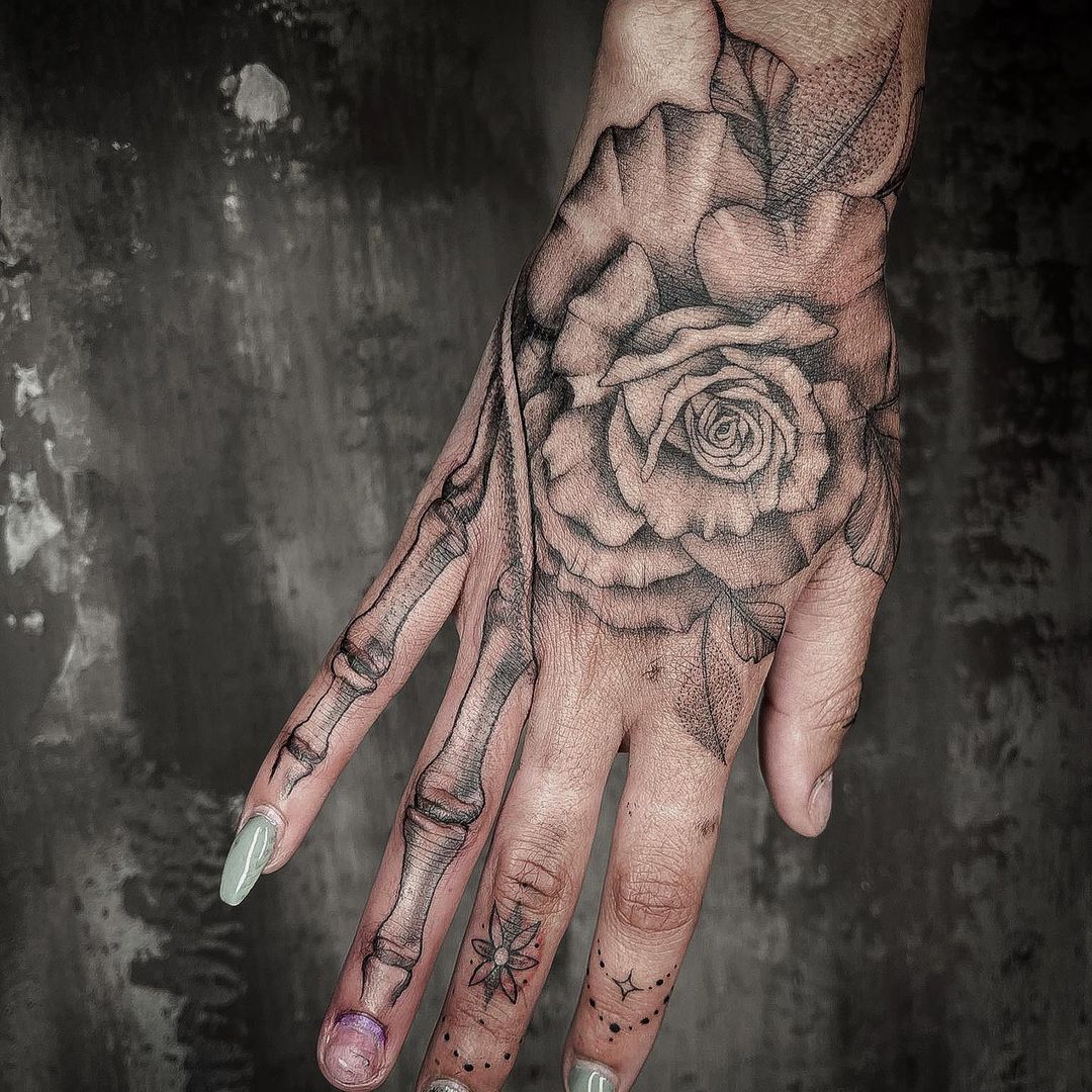 Mani donna tatuaggio di ossa e fiore