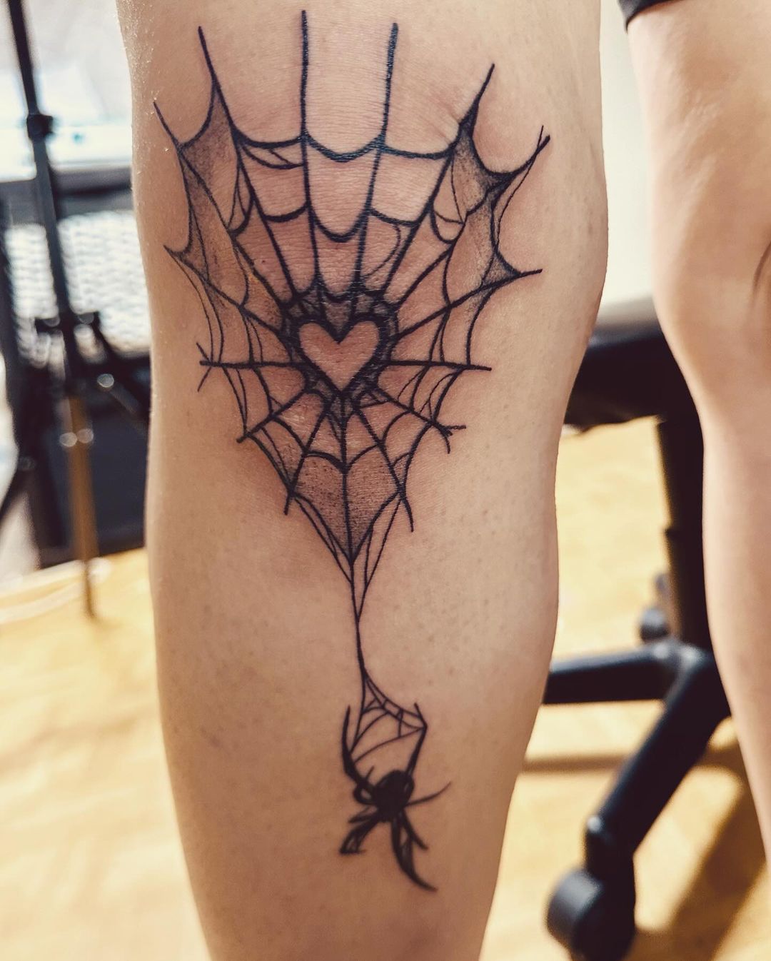 Ragno che scende da una ragnatela con un cuore al centro